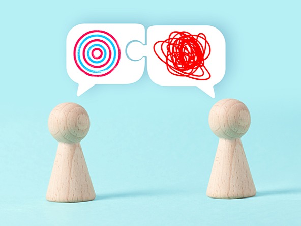 wooden figures with speech bubbles, one with a spiral and one with a messy scribble